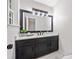 This bathroom features a dark vanity with drawers and cabinets and a large framed mirror at 302 Davis Rd, Stockbridge, GA 30281