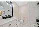 Bright bathroom featuring marble tile in the shower and floor plus a white vanity and framed mirror at 302 Davis Rd, Stockbridge, GA 30281