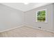 This bright bedroom features a window with views of the yard and light wood-look flooring at 302 Davis Rd, Stockbridge, GA 30281