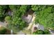 Serene aerial view of a home nestled among lush green trees, featuring a circular patio and long driveway at 3311 Creek Hollow Dr, Marietta, GA 30062
