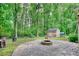 Backyard featuring a fire pit, stone patio, shed, and lush greenery at 3311 Creek Hollow Dr, Marietta, GA 30062