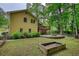Large backyard showcasing a wooden deck, stone patio, landscaping, and abundant trees and nature at 3311 Creek Hollow Dr, Marietta, GA 30062