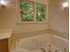 Bathroom showcasing a jacuzzi tub with tile surround, vanity and window at 3311 Creek Hollow Dr, Marietta, GA 30062