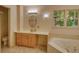 Well-lit bathroom featuring a soaking tub, vanity with sink, and a large window offering a scenic view at 3311 Creek Hollow Dr, Marietta, GA 30062