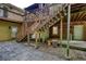 Exterior view featuring wooden deck stairs, a stone patio, and partially exposed basement area at 3311 Creek Hollow Dr, Marietta, GA 30062