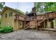 Two-story yellow home featuring a spacious wooden deck, brick chimney, and stone patio at 3311 Creek Hollow Dr, Marietta, GA 30062