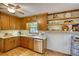 Kitchen featuring wooden cabinets, open shelving, stainless steel dishwasher, and neutral countertop at 3311 Creek Hollow Dr, Marietta, GA 30062