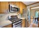 Modern kitchen with stainless steel appliances, wood cabinets, and view of the dining room at 3311 Creek Hollow Dr, Marietta, GA 30062