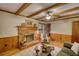 Living room with a brick fireplace, wood paneling, hardwood floors, and comfortable seating at 3311 Creek Hollow Dr, Marietta, GA 30062