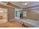 Spacious main bedroom featuring large windows, plush carpeting, and a conveniently located bathroom with a soaking tub at 3311 Creek Hollow Dr, Marietta, GA 30062