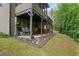 A backyard with a covered deck featuring dining and entertaining space and manicured garden beds at 436 Barnett St, Woodstock, GA 30188
