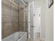 Well-maintained bathroom featuring a shower/tub combo with neutral tile and a glass door at 436 Barnett St, Woodstock, GA 30188