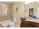 This is a tiled bathroom with a tub and shower combo and a framed mirror above a granite countertop at 436 Barnett St, Woodstock, GA 30188