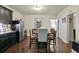 A kitchen and dining area with dark cabinets and stainless steel appliances open to the other rooms of the home at 436 Barnett St, Woodstock, GA 30188