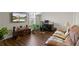 Bright and airy living room with a large TV, lots of plants and dark hardwood floors at 436 Barnett St, Woodstock, GA 30188