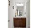 Stylish powder room featuring a vanity with brown cabinetry, white countertop, and modern fixtures at 436 Barnett St, Woodstock, GA 30188