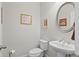 Neat powder room with pedestal sink, commode and decoratively painted walls with coordinating artwork at 436 Barnett St, Woodstock, GA 30188