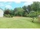 Expansive green backyard with mature trees and a wooden fence line, perfect for outdoor activities at 47 Cliff Ct, Villa Rica, GA 30180