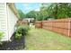 A fenced backyard features green grass, mulch beds, and flowering shrubs, offering privacy at 47 Cliff Ct, Villa Rica, GA 30180