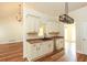 Bright kitchen has stainless dishwasher, wooden cabinets, and wood flooring at 47 Cliff Ct, Villa Rica, GA 30180
