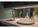This is a close-up of the bar with a gold faucet, marble countertop, decanter, and glasses at 541 Londonberry Rd, Atlanta, GA 30327