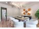 Dining area with a long table, bright white chairs, modern chandelier and view into the hallway at 541 Londonberry Rd, Atlanta, GA 30327