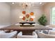Dining area with a long table, bright white chairs, modern chandelier, and stylish wood slice wall decor at 541 Londonberry Rd, Atlanta, GA 30327
