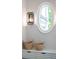 Hallway features a brick wall, accent lighting, an oval window, and woven baskets, adding charm and character at 541 Londonberry Rd, Atlanta, GA 30327