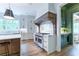 Well-appointed kitchen featuring custom range hood, stainless steel appliances, and hardwood floors with a glimpse of a wet bar at 541 Londonberry Rd, Atlanta, GA 30327