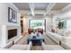 Open-concept living room featuring coffered ceilings, a fireplace, built-ins, and outdoor living at 541 Londonberry Rd, Atlanta, GA 30327