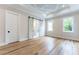Spacious main bedroom featuring a tray ceiling, hardwood floors, and sliding barn door to the ensuite bathroom at 541 Londonberry Rd, Atlanta, GA 30327