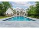 A luxurious backyard pool with stone surround, set against a pristine white home and lush landscaping at 541 Londonberry Rd, Atlanta, GA 30327