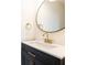 Bathroom vanity featuring modern gold fixtures and a black framed round mirror at 6109 Park Ave, Atlanta, GA 30342