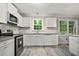 Well-equipped kitchen features a window, white cabinetry, stainless steel appliances and tile backsplash at 6549 Biscayne Way, Douglasville, GA 30135