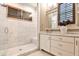 Modern bathroom with marble tile, frameless shower, vanity and custom mirror at 171 Beverly Ne Rd, Atlanta, GA 30309
