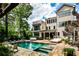 A luxurious backyard pool with a spa is surrounded by patio furniture and lush landscaping at 171 Beverly Ne Rd, Atlanta, GA 30309