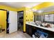 Bright bathroom with a shower, large mirror, vanity with dark cabinets and yellow walls at 1905 Buford Ct, Conyers, GA 30094