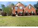 Beautiful two-story brick home featuring a lush green lawn and manicured shrubbery at 1905 Buford Ct, Conyers, GA 30094