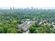 Stunning aerial view of a modern community nestled among lush trees with a city skyline in the background at 4046 Hazel Nut Ln, Atlanta, GA 30342
