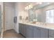 Bathroom with a dual sink vanity, tiled floors, glass shower and a large mirror at 4046 Hazel Nut Ln, Atlanta, GA 30342