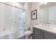 Bathroom featuring gray vanity with white countertop, framed mirror, and a tiled shower/tub with glass door at 4046 Hazel Nut Ln, Atlanta, GA 30342