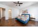 Bedroom boasts rich hardwood floors, a ceiling fan, and a stylish bed complemented by a colorful painting at 4046 Hazel Nut Ln, Atlanta, GA 30342