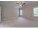 Neutral bedroom with plush carpet, a ceiling fan with lights, and backyard view at 1482 Alcovy Station Rd, Covington, GA 30014