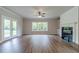 Bright living room boasts hardwood floors, fireplace, and backyard view from windows at 1482 Alcovy Station Rd, Covington, GA 30014