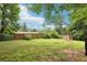 Spacious backyard featuring a lush green lawn, mature trees, and a weathered storage shed at 309 Carmen Ct, Lawrenceville, GA 30046