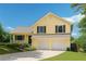 Inviting yellow home featuring a two-car garage, well-kept lawn, and a charming front porch, creating a welcoming curb appeal at 309 Carmen Ct, Lawrenceville, GA 30046