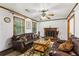 Cozy living room with a brick fireplace, wood trim, and plush leather furniture, creating a warm and inviting atmosphere at 309 Carmen Ct, Lawrenceville, GA 30046