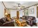 Inviting living room featuring classic wood trim, comfortable leather seating, and a ceiling fan for a relaxed and welcoming ambiance at 309 Carmen Ct, Lawrenceville, GA 30046
