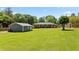Expansive backyard view showing the house, detached garage, and lush green lawn at 3872 Francis Dr, Powder Springs, GA 30127