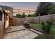 Charming backyard featuring a stone patio, grill, string lights, and a wooden privacy fence at 3872 Francis Dr, Powder Springs, GA 30127